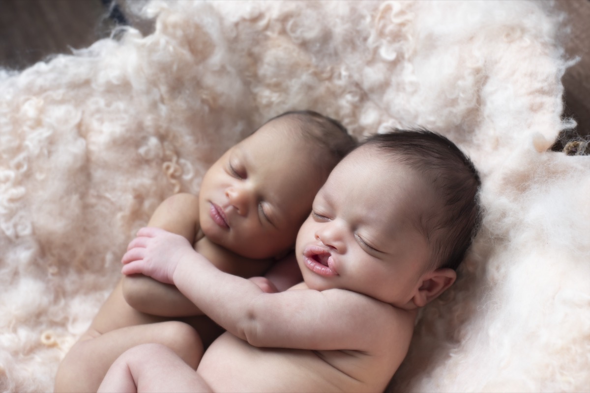 Newborn twins cuddling